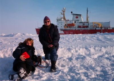 La Dolors Vaqué i la Marta Estrada descansant sobre l’oceà Àrtic glaçat. Al fons el vaixell oceànic canadenc Amundsen amb el que feien la campanya. Font: Dolors Vaqué